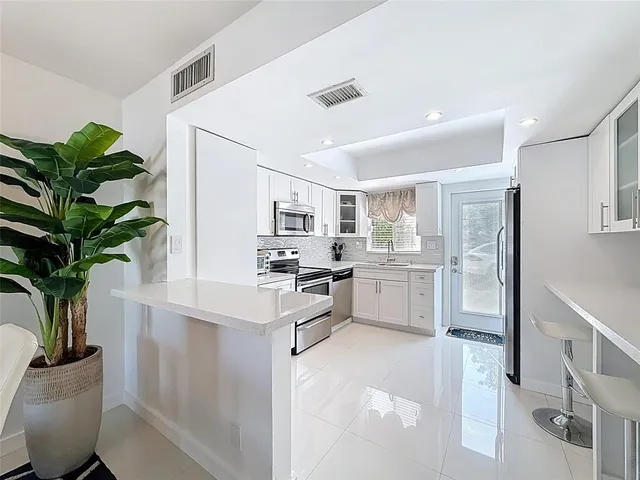 a kitchen with white cabinets and a potted plant