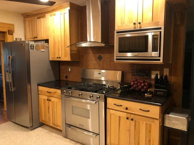 a kitchen with stainless steel appliances granite countertop a stove a microwave and a refrigerator