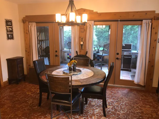 a dining room with furniture a chandelier and window