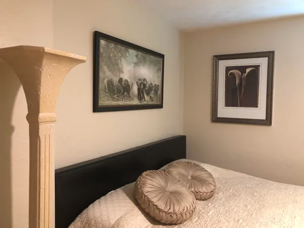 a bedroom with a bed and a painting on the wall