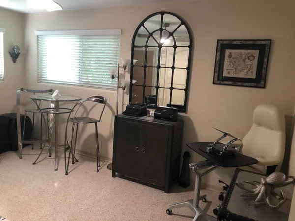 a view of a workspace with furniture and a window