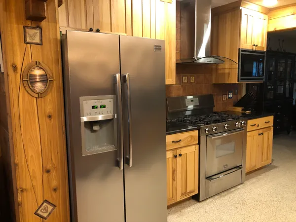 a kitchen with stainless steel appliances granite countertop a refrigerator and a stove