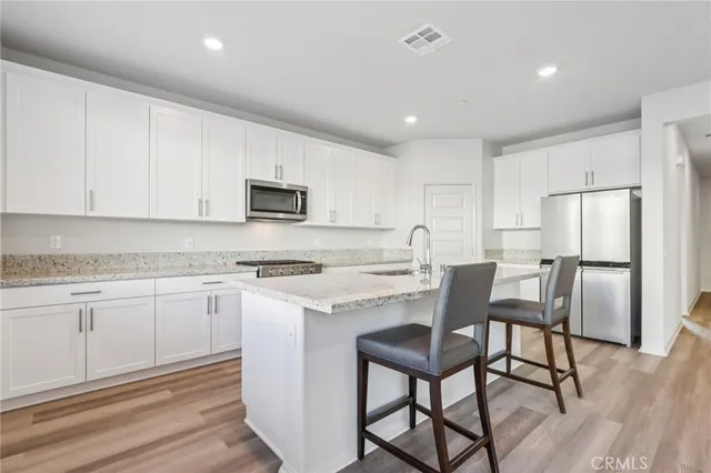 a kitchen with a dining table chairs refrigerator and cabinets