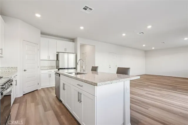 a kitchen with white cabinets appliances and sink