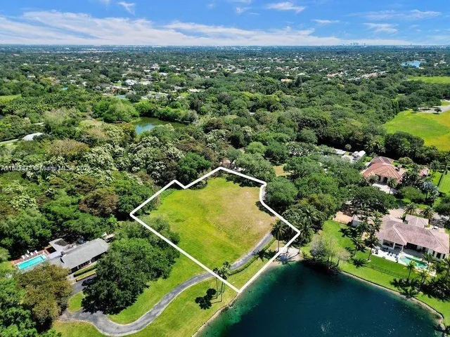 an aerial view of residential houses with outdoor space and trees
