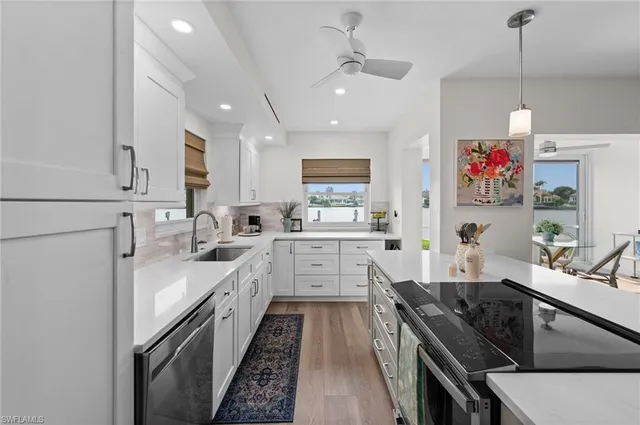 a kitchen with granite countertop a sink stove and cabinets