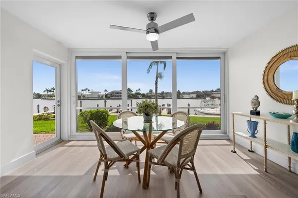 a dining room with furniture and a floor to ceiling window