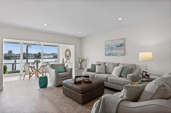 a living room with furniture and a view of kitchen
