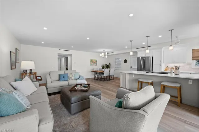 a living room with furniture white walls and kitchen view