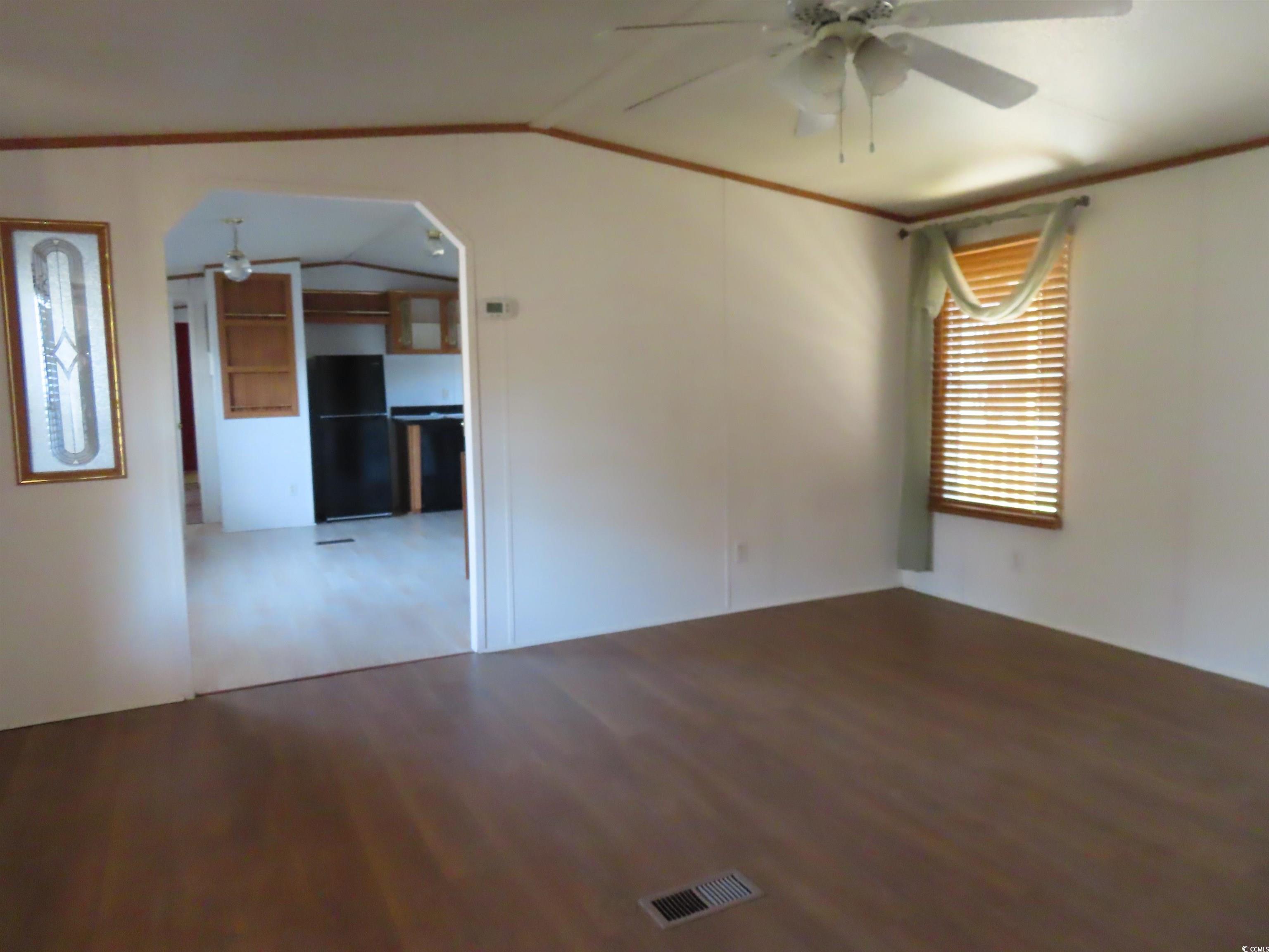 9323 Shoveler Drive Murrells Inlet, SC 29576 - Photo 18 of 23 Unfurnished room with visible vents, arched walkways, ceiling fan, wood finished floors, and lofted ceiling