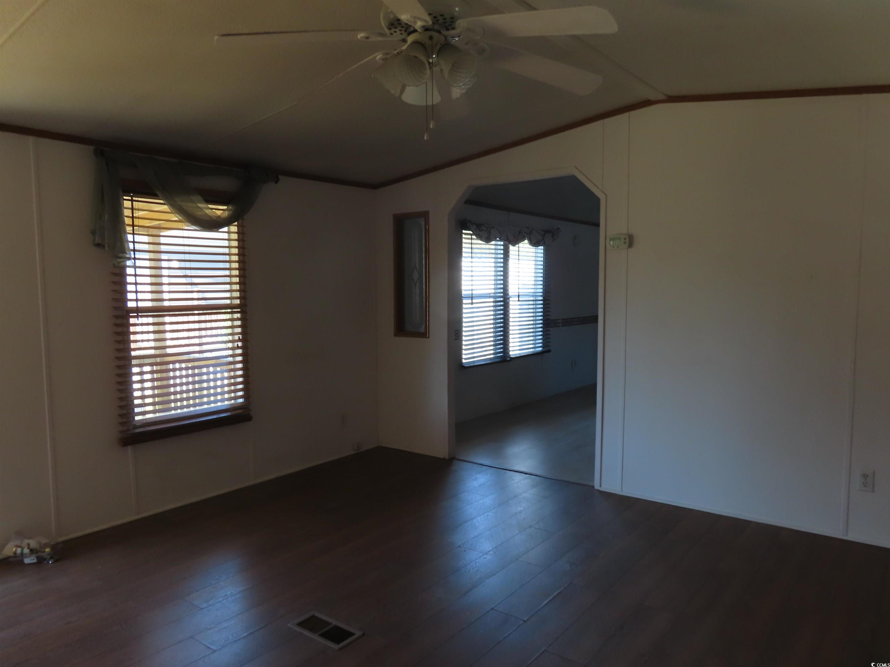 9323 Shoveler Drive Murrells Inlet, SC 29576 - Photo 19 of 23 Spare room with visible vents, vaulted ceiling, a ceiling fan, and dark wood finished floors