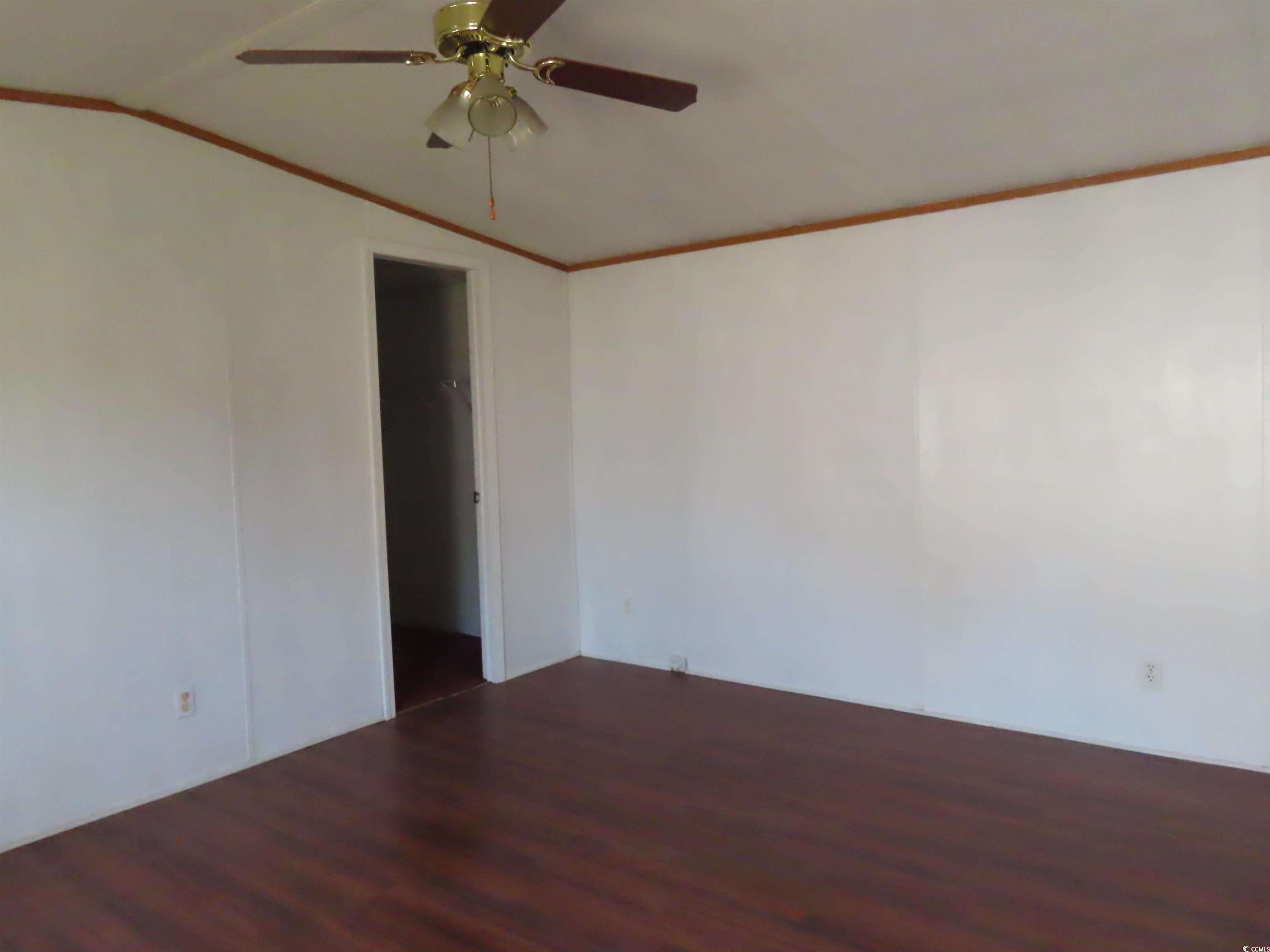 9323 Shoveler Drive Murrells Inlet, SC 29576 - Photo 10 of 23 Empty room featuring wood finished floors, ceiling fan, ornamental molding, and lofted ceiling