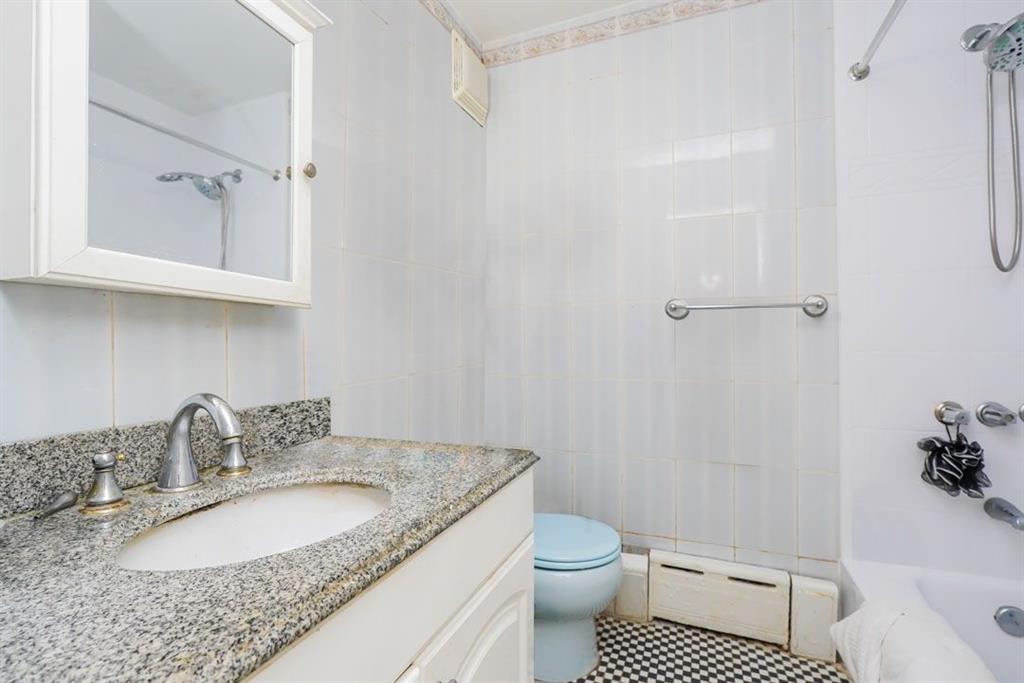 2329 West Street Brooklyn, NY 11223 - Photo 18 of 26 a bathroom with a granite countertop sink toilet and shower