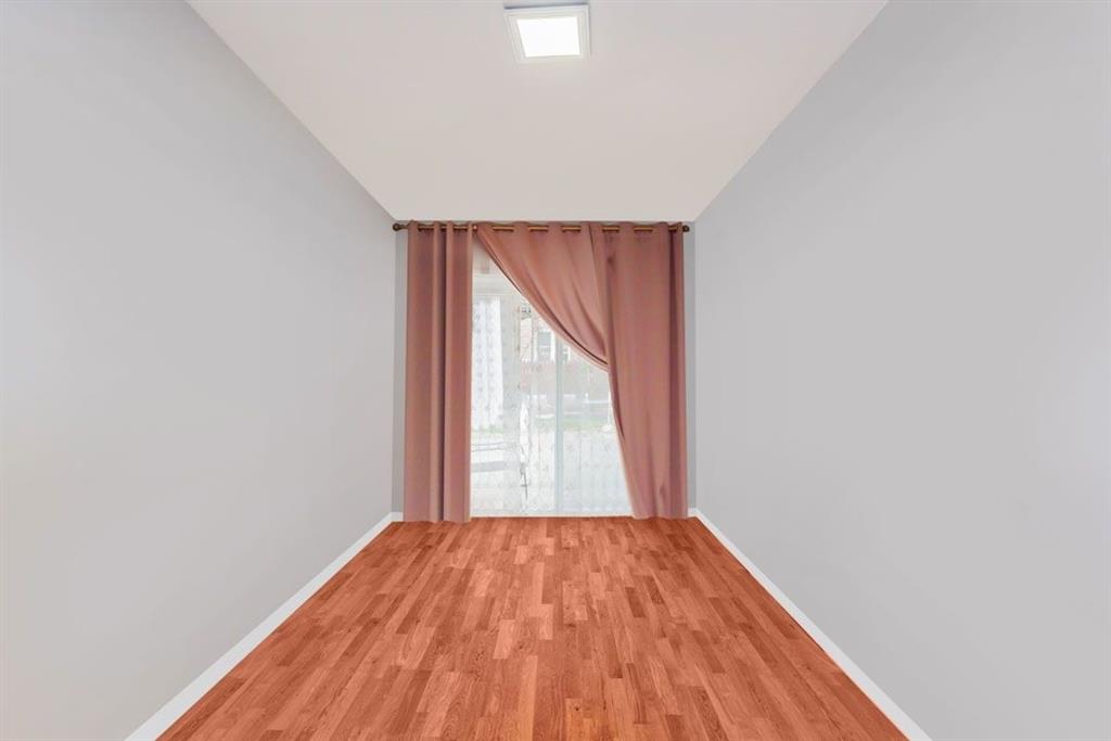 2329 West Street Brooklyn, NY 11223 - Photo 7 of 26 an empty room with wooden floor and windows