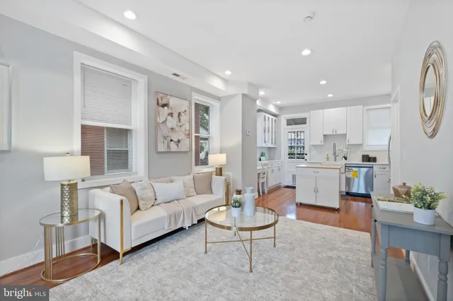 a living room with furniture and a dining table with kitchen view