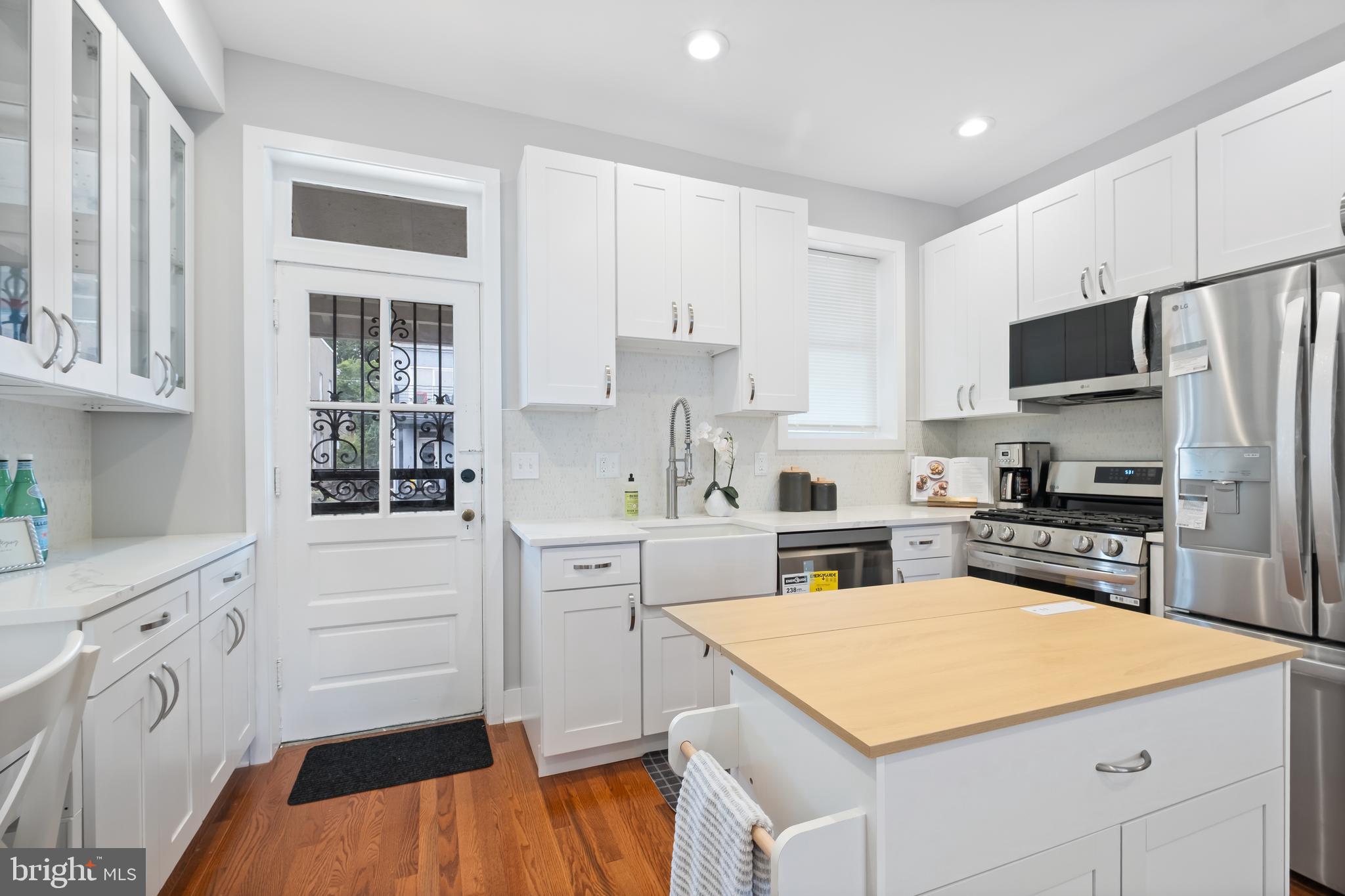 607 Tuckerman Street Northwest Washington, DC 20011 - Photo 7 of 25 a kitchen with white cabinets stainless steel appliances and sink