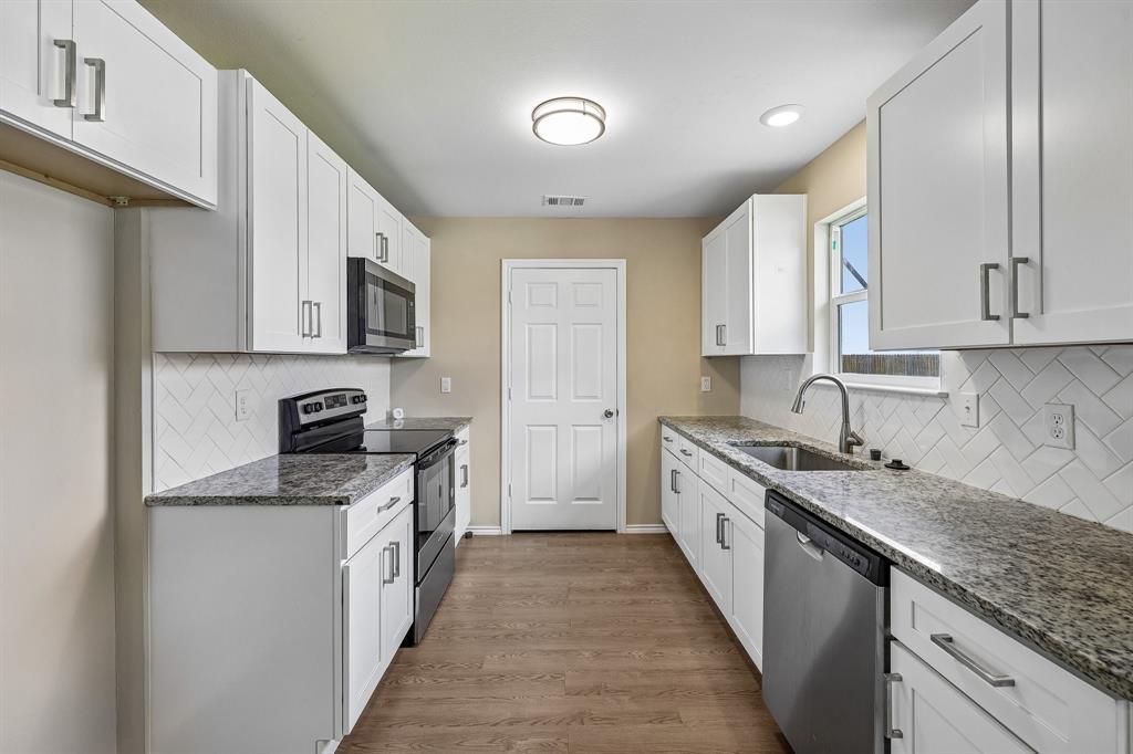 433 Whitney Court Rio Vista, TX 76093 - Photo 9 of 27 a kitchen with stainless steel appliances granite countertop a sink stove and cabinets