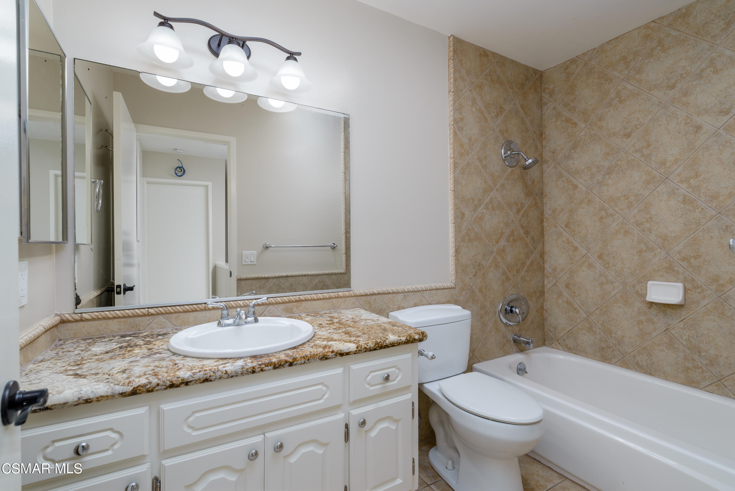 1667 Edgewater Lane Camarillo, CA 93010 - Photo 26 of 32 a bathroom with a granite countertop sink a toilet a mirror a bathtub and shower