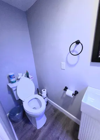 a bathroom with a granite countertop toilet and a sink