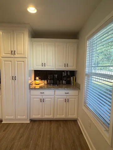 a kitchen with stainless steel appliances a refrigerator a stove and white cabinets