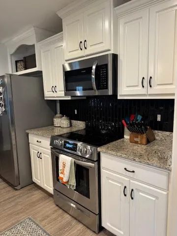 a kitchen with stainless steel appliances granite countertop a stove a microwave and cabinets