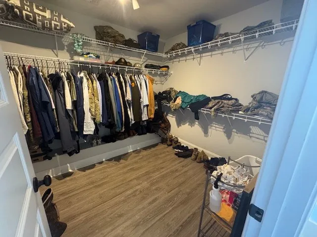 a view of walk in closet with clothes and shoes