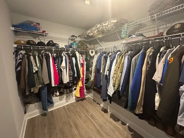 a view of walk in closet with clothes and shoes