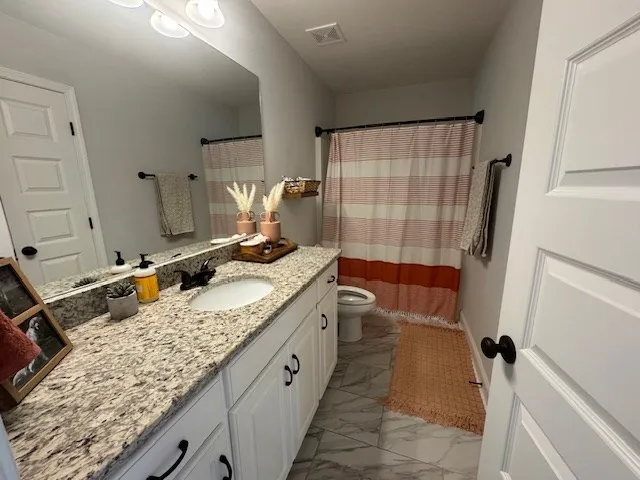 a bathroom with a granite countertop sink and a shower