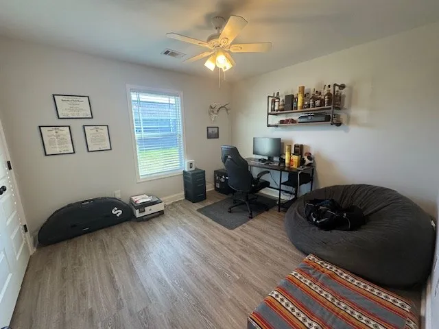 a living room with furniture and a ceiling fan
