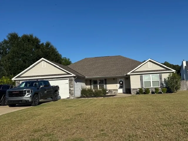 a front view of a house with a garden and trees