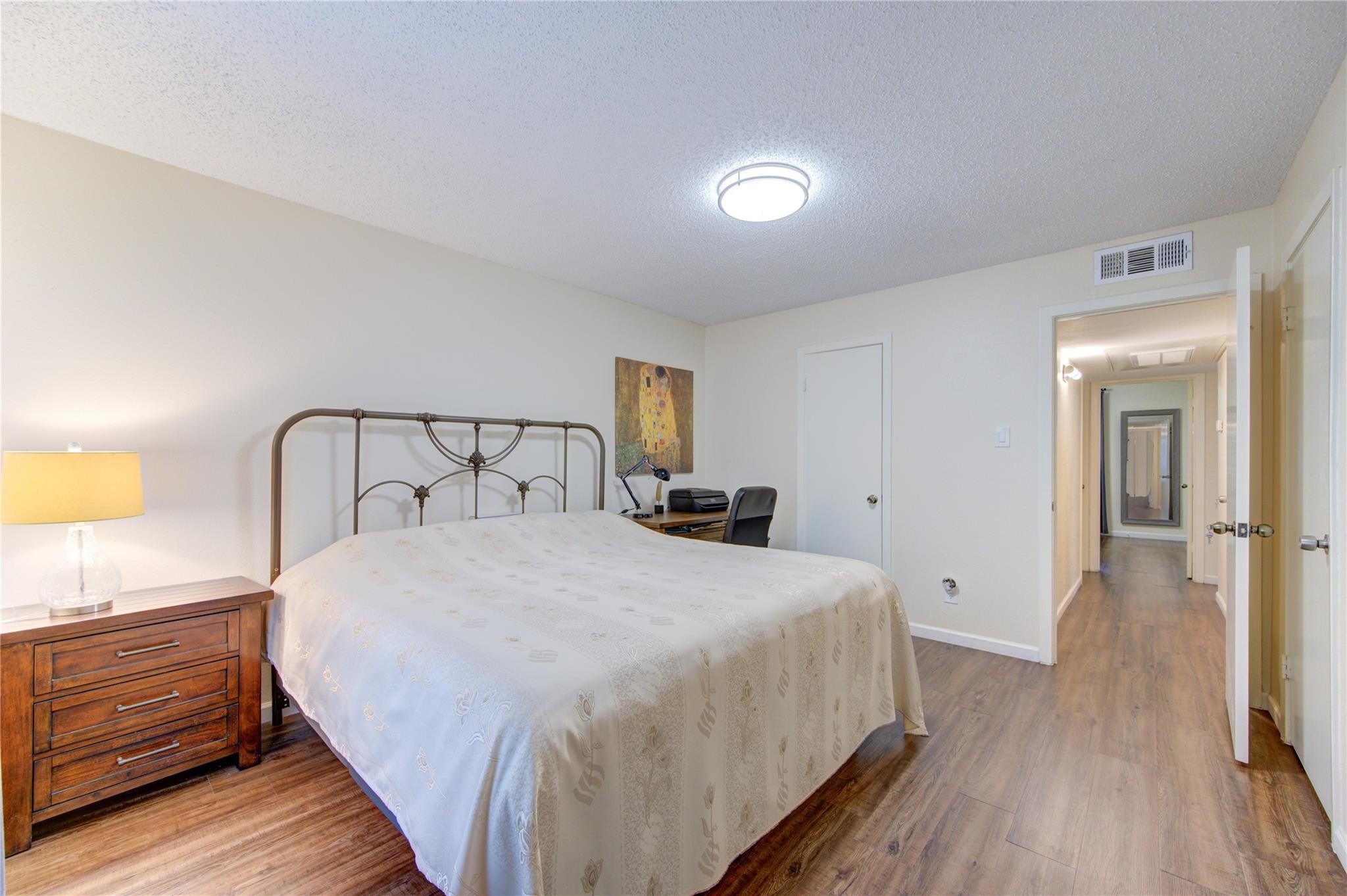 1901 South Voss Road, Unit 4 Houston, TX 77057 - Photo 12 of 26 a bedroom with a bed and wooden floor