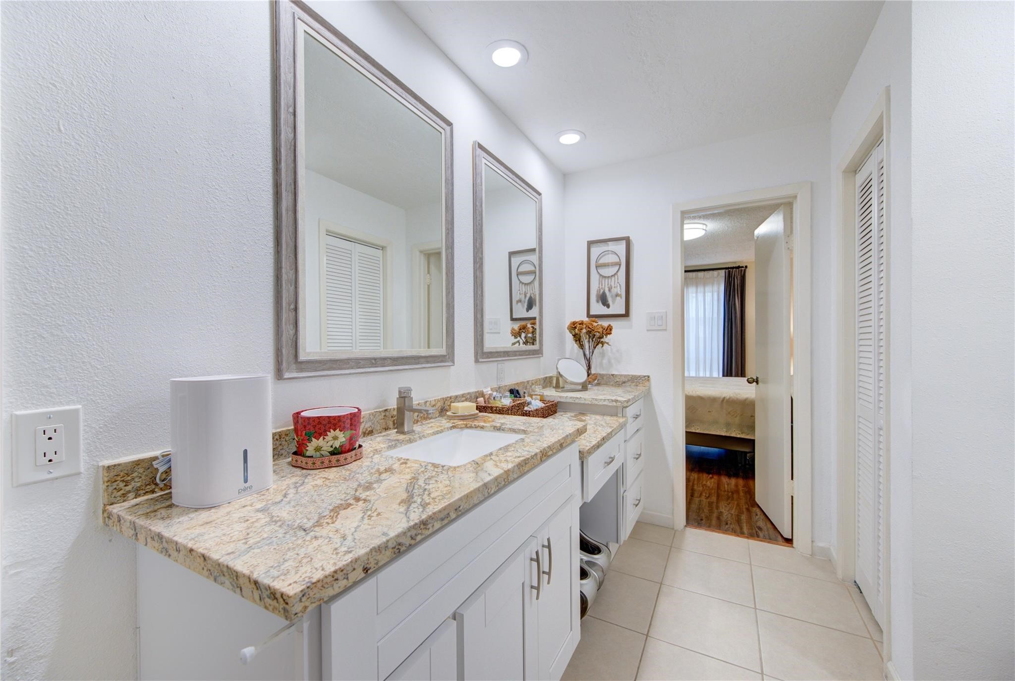 1901 South Voss Road, Unit 4 Houston, TX 77057 - Photo 18 of 26 a bathroom with a granite countertop sink and a mirror