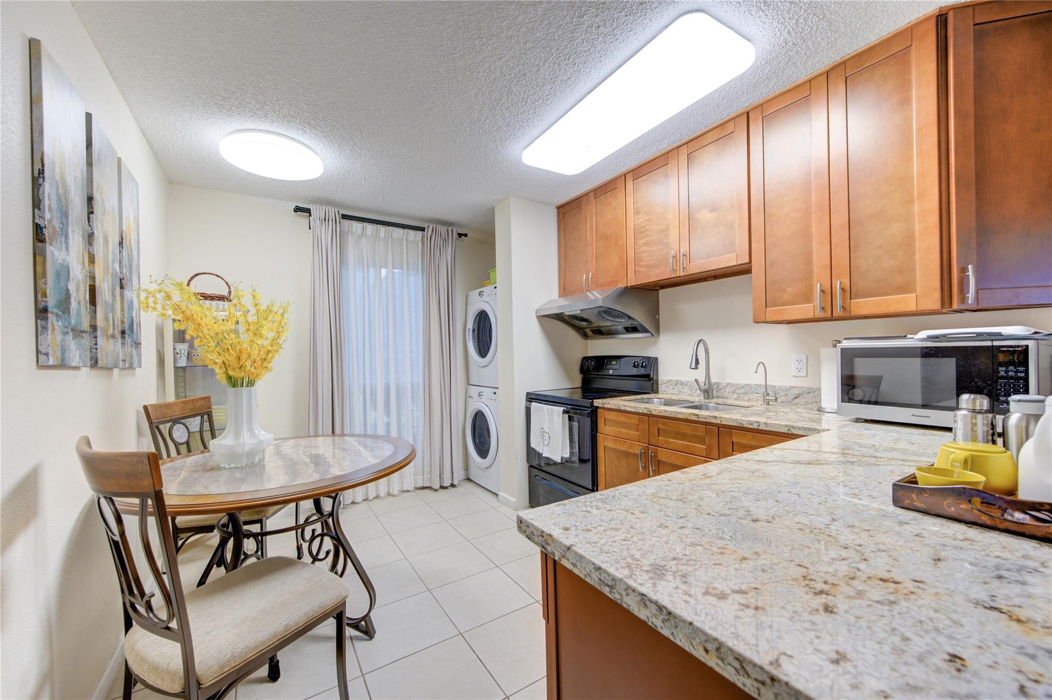1901 South Voss Road, Unit 4 Houston, TX 77057 - Photo 7 of 26 a kitchen with stainless steel appliances granite countertop a table chairs and a refrigerator