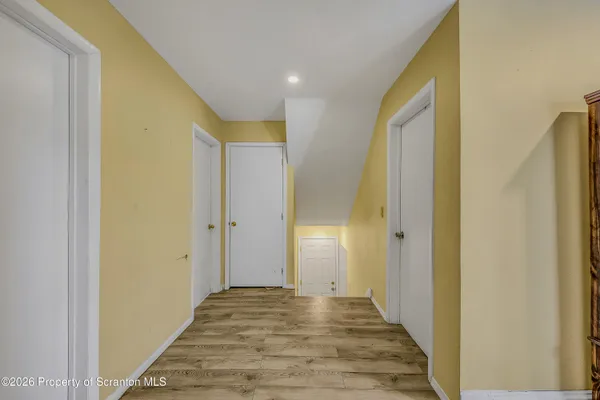 a view of a hallway with wooden floor