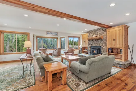 a living room with fireplace furniture and a large window