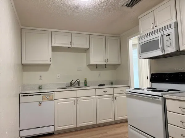 a kitchen with a stove a refrigerator and a sink