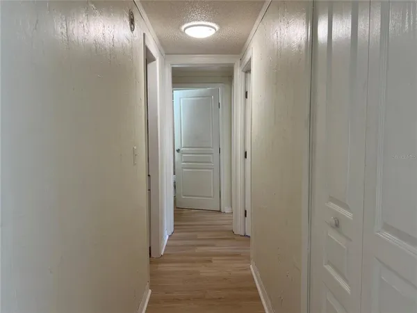 an empty room with windows and ceiling fan