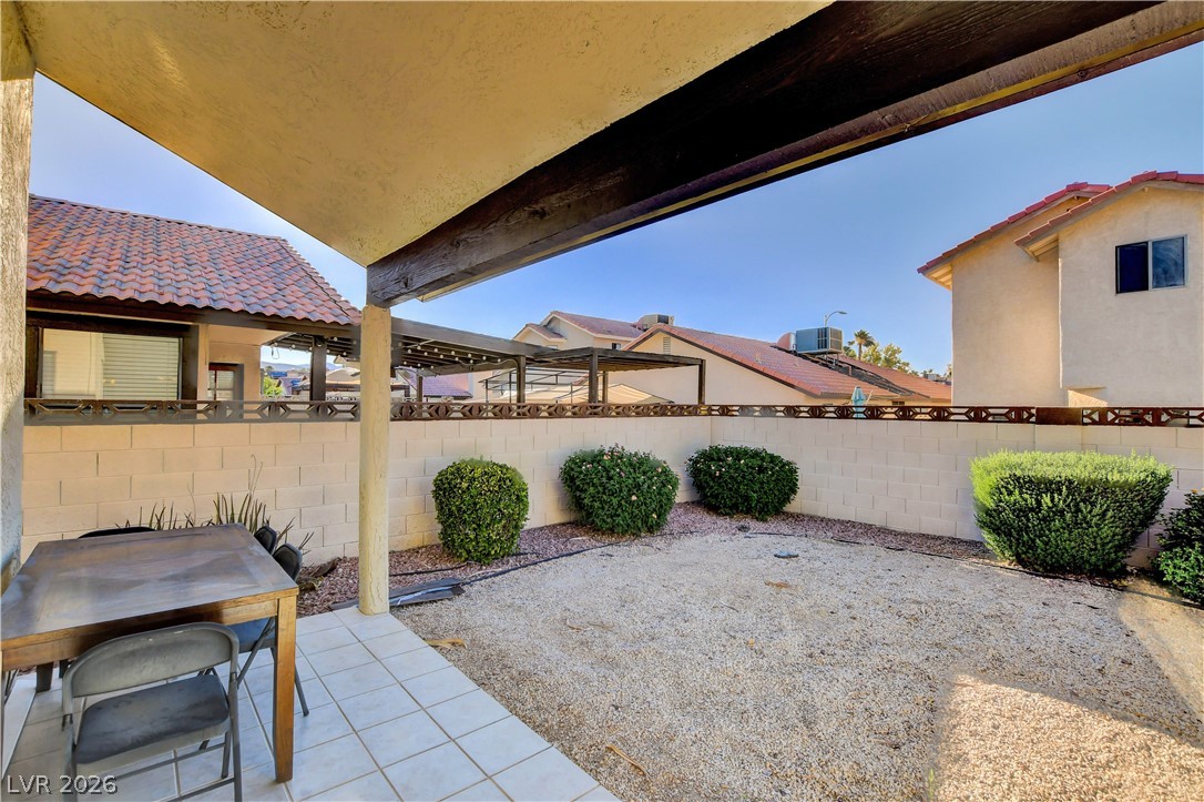 6440 Hartwood Road Las Vegas, NV 89108 - Photo 52 of 59 A tranquil backyard retreat features a covered patio with tiled flooring and low-maintenance landscaping.