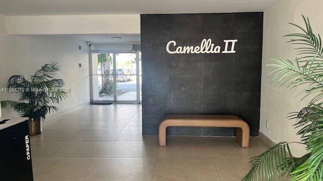 1780 Northeast 191st Street, Unit 8112 Miami, FL 33179 - Photo 1 of 24 a hallway with a bench and a potted plant