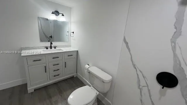 a bathroom with a granite countertop toilet sink and mirror