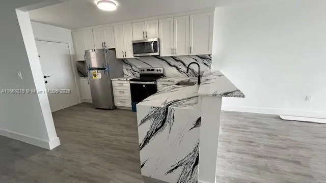 a kitchen with stainless steel appliances a refrigerator and a stove top oven