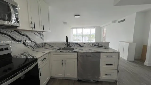 a kitchen with stainless steel appliances granite countertop a sink stove and cabinets
