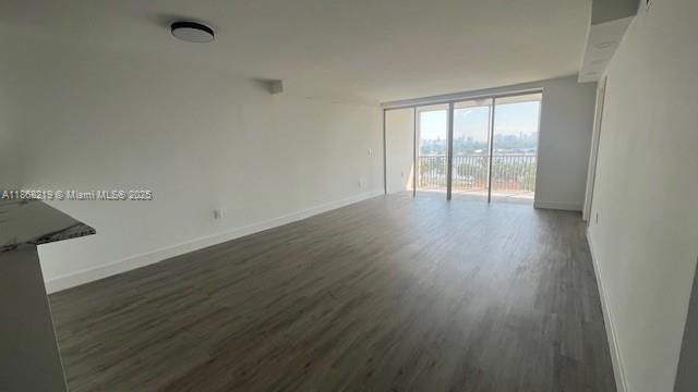 1780 Northeast 191st Street, Unit 8112 Miami, FL 33179 - Photo 6 of 24 a view of an empty room with wooden floor and a window