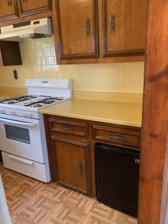 27 Fulton Street Fall River, MA 02720 - Photo 24 of 41 a kitchen with granite countertop a stove top oven microwave and cabinets