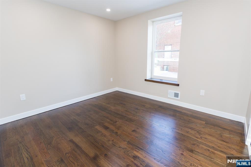 17 Warren Street, Unit 2 Bergenfield, NJ 07621 - Photo 14 of 28 an empty room with wooden floor and windows