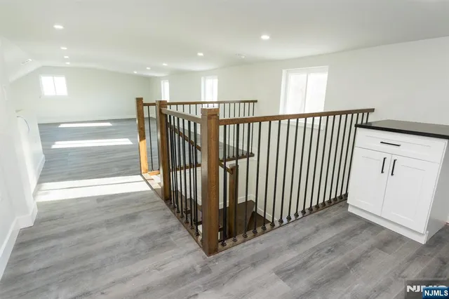 a view of a hallway with wooden floor and windows