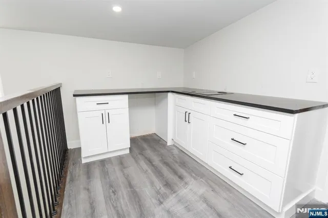 a view of white cabinets and wooden floor