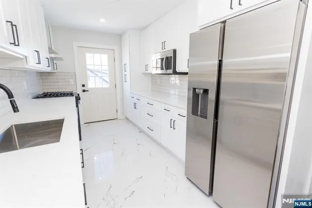 a kitchen with stainless steel appliances a refrigerator and a sink