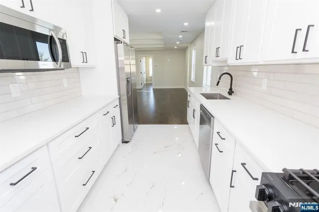 a kitchen with kitchen island white cabinets and sink