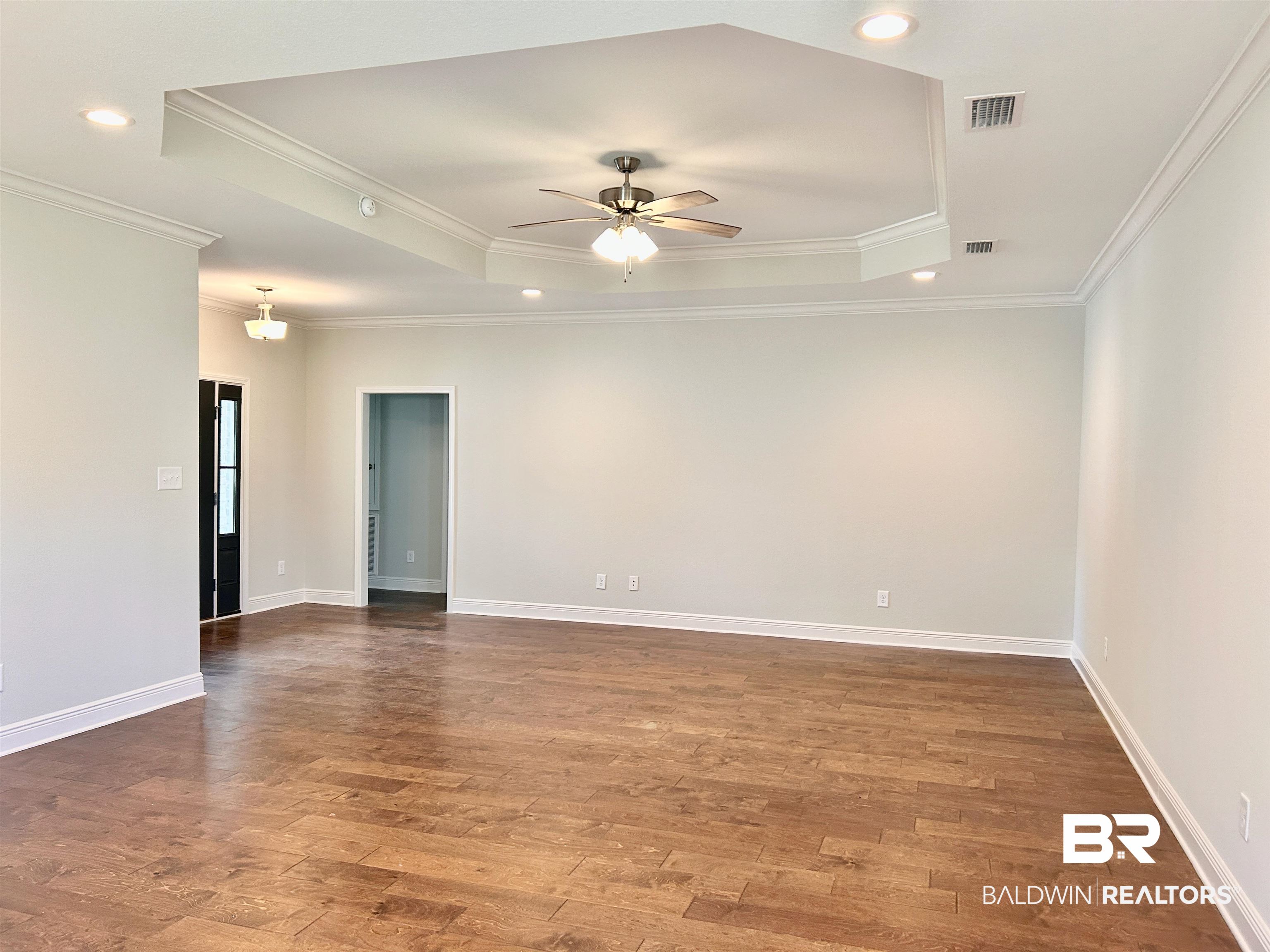 1267 Pembroke Way Foley, AL 36535 - Photo 6 of 17 Spare room with crown molding, wood-type flooring, a tray ceiling, and ceiling fan